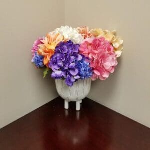 A One of A Kind filled with colorful flowers on a table.