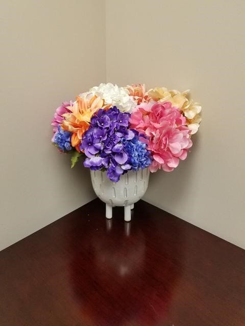 A One of A Kind filled with colorful flowers on a table.