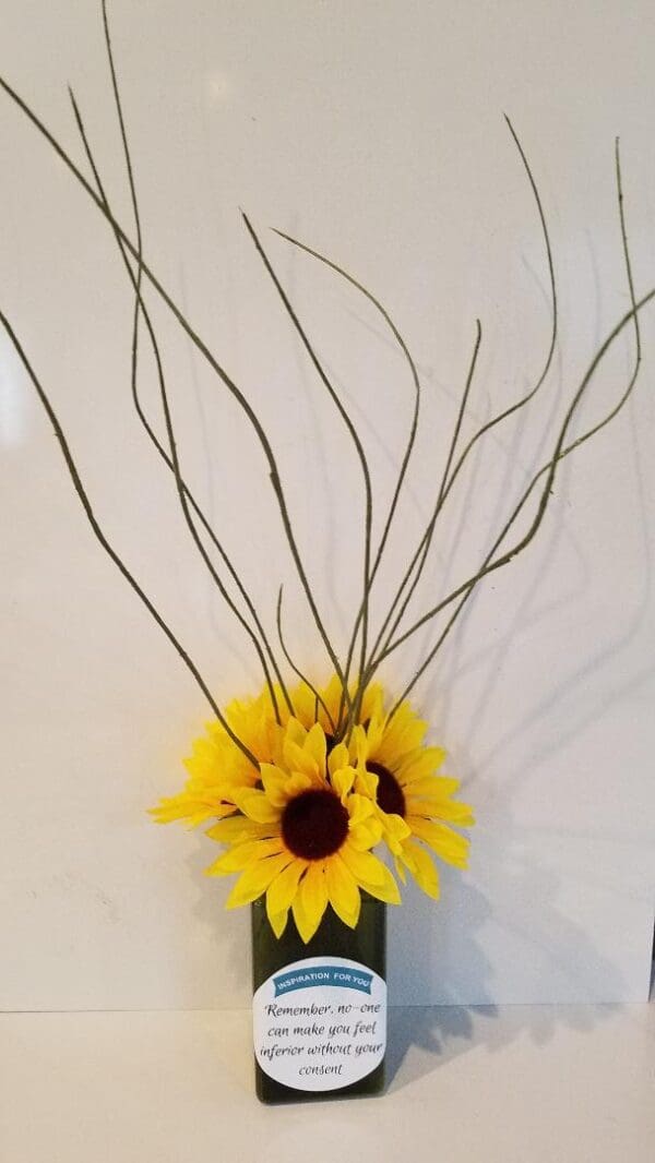 An Inspiration Bottle with sunflowers and twigs in it.