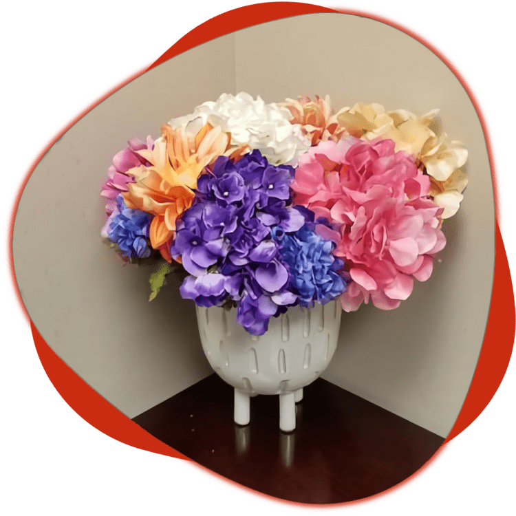 A vase of flowers on the corner of a table.