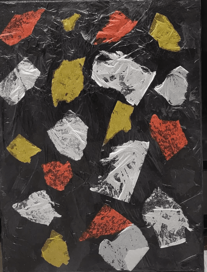 A painting with red, yellow, and black pieces of paper.