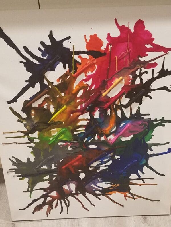 Colorful melted crayons on a white canvas.