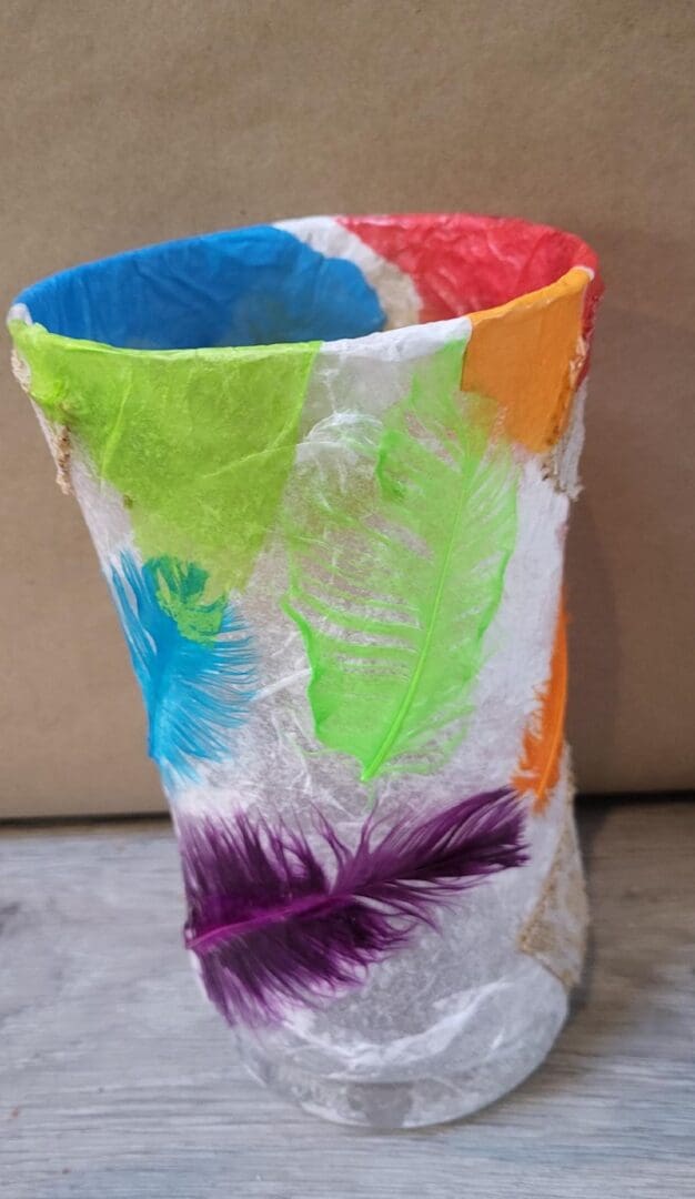 A colorful paper lantern with a feather design.