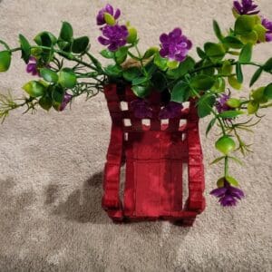 A small red chair with purple flowers.