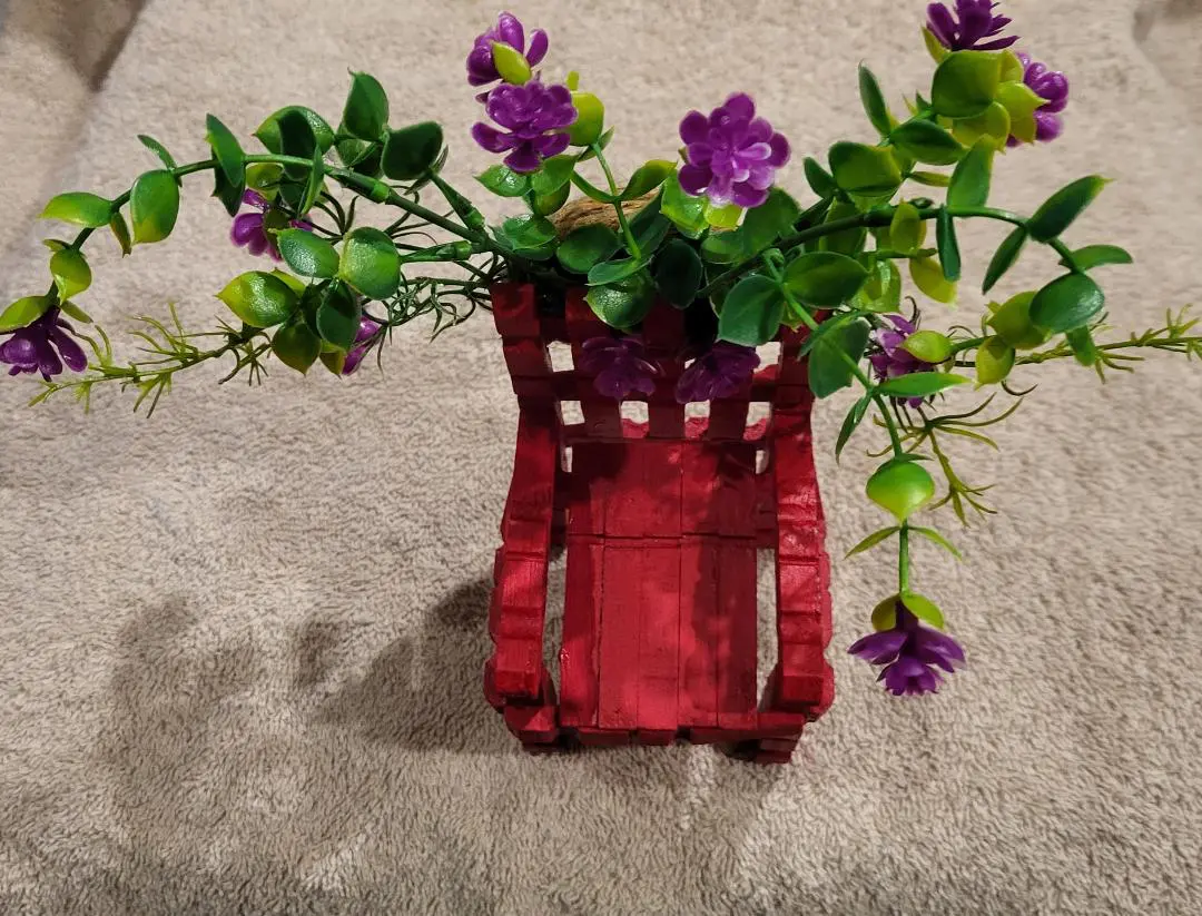 A small red chair with purple flowers.