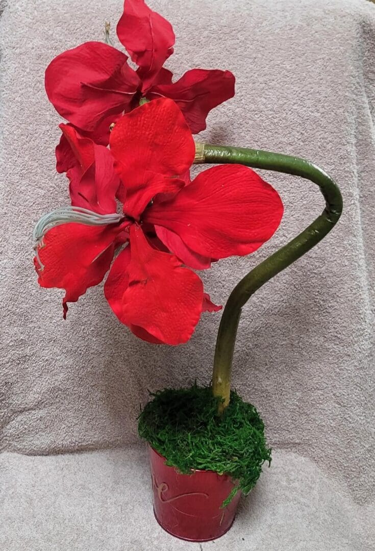 A photo of a fake red flower in a pot.