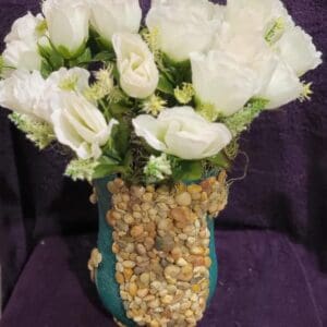 A bouquet of white roses in a blue vase.