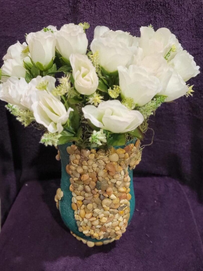 A bouquet of white roses in a blue vase.