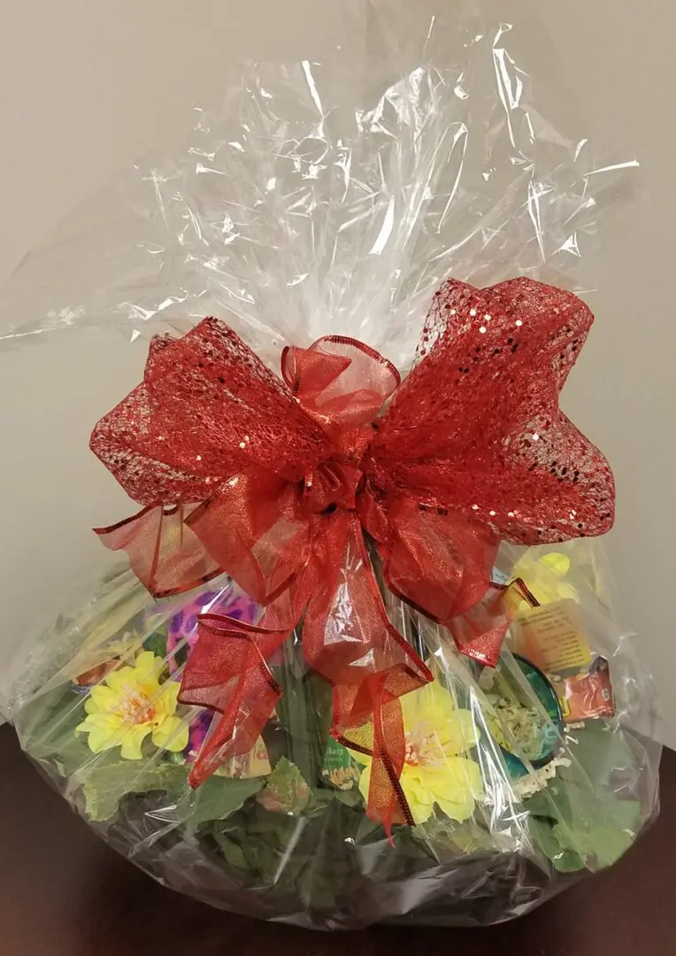 A gift basket with a red bow on top.